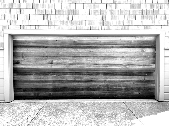 a wooden garage door on a brick building